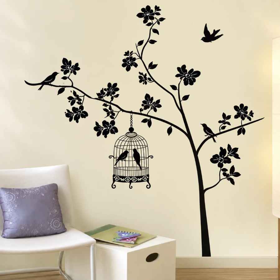 Sticker Cage à Oiseaux noir posé sur un mur clair dans une pièce avec fauteuil blanc